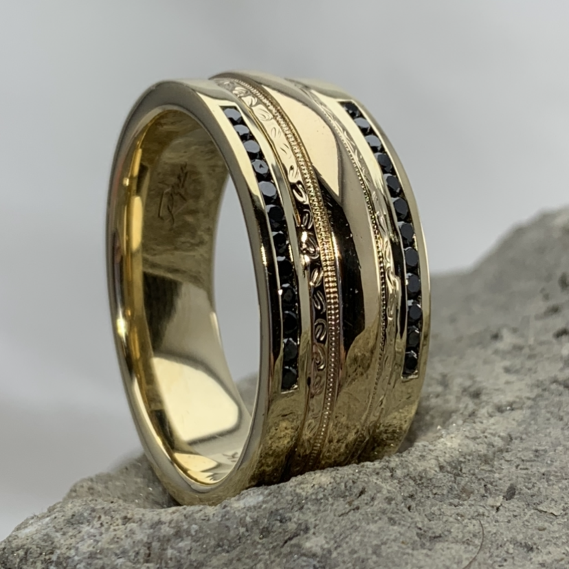 custom yellow gold band with channel set black diamonds and scroll detail