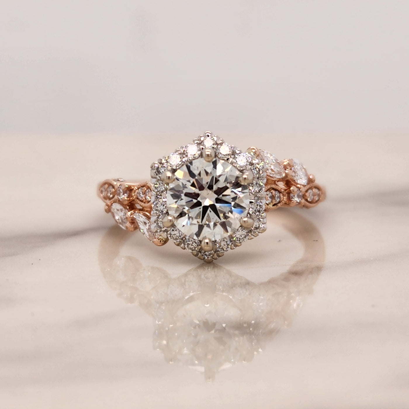 2 tone rose and white gold engagement ring with hexagon halo and marquise accents