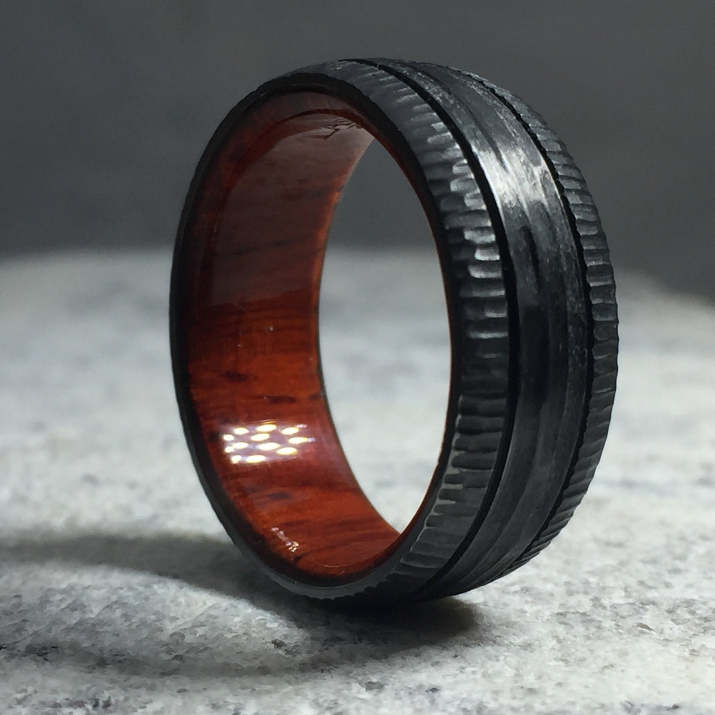 zirconium wedding band with wood sleeve and tree bark finish