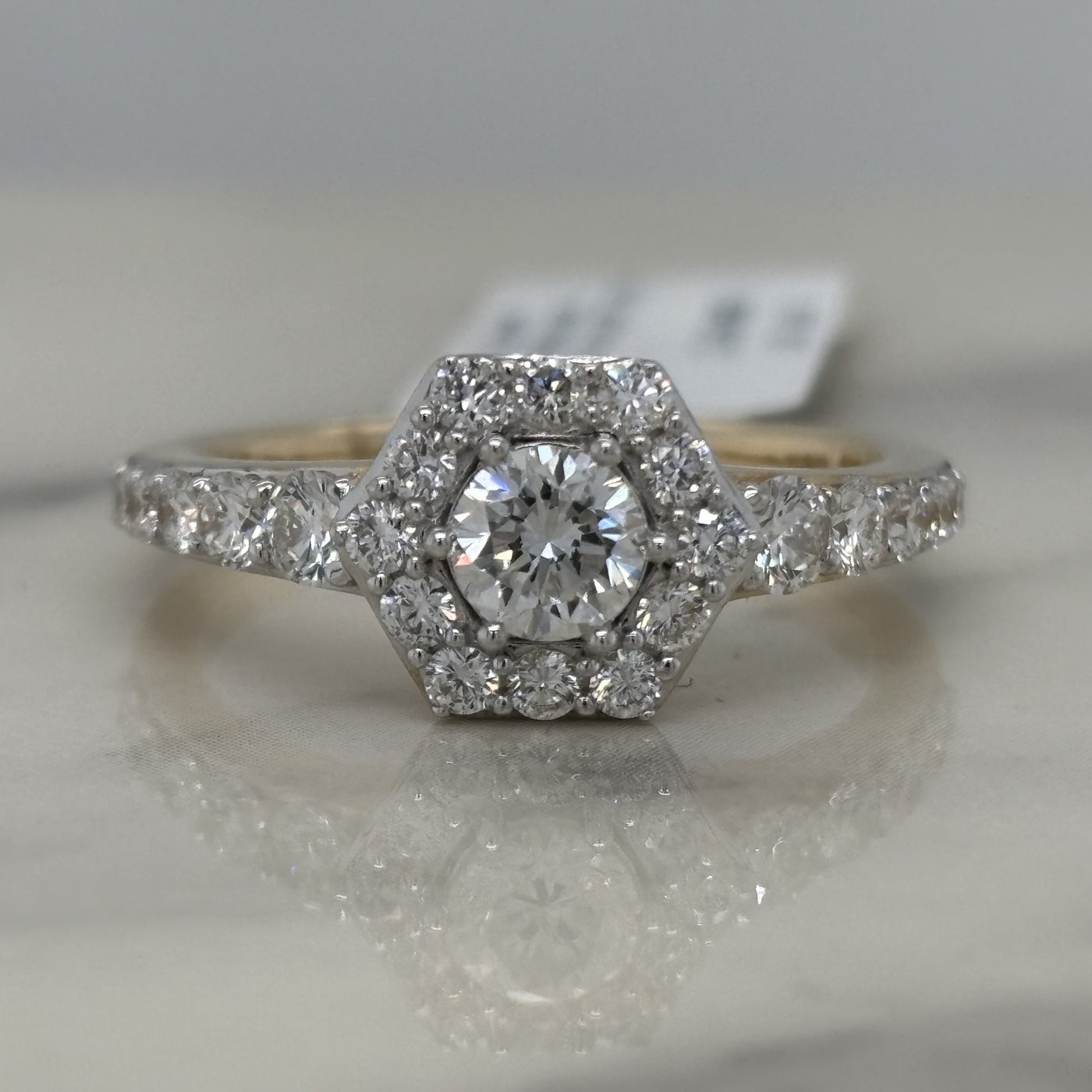 yellow gold hexagon halo engagement ring with round center stone and round accent diamonds