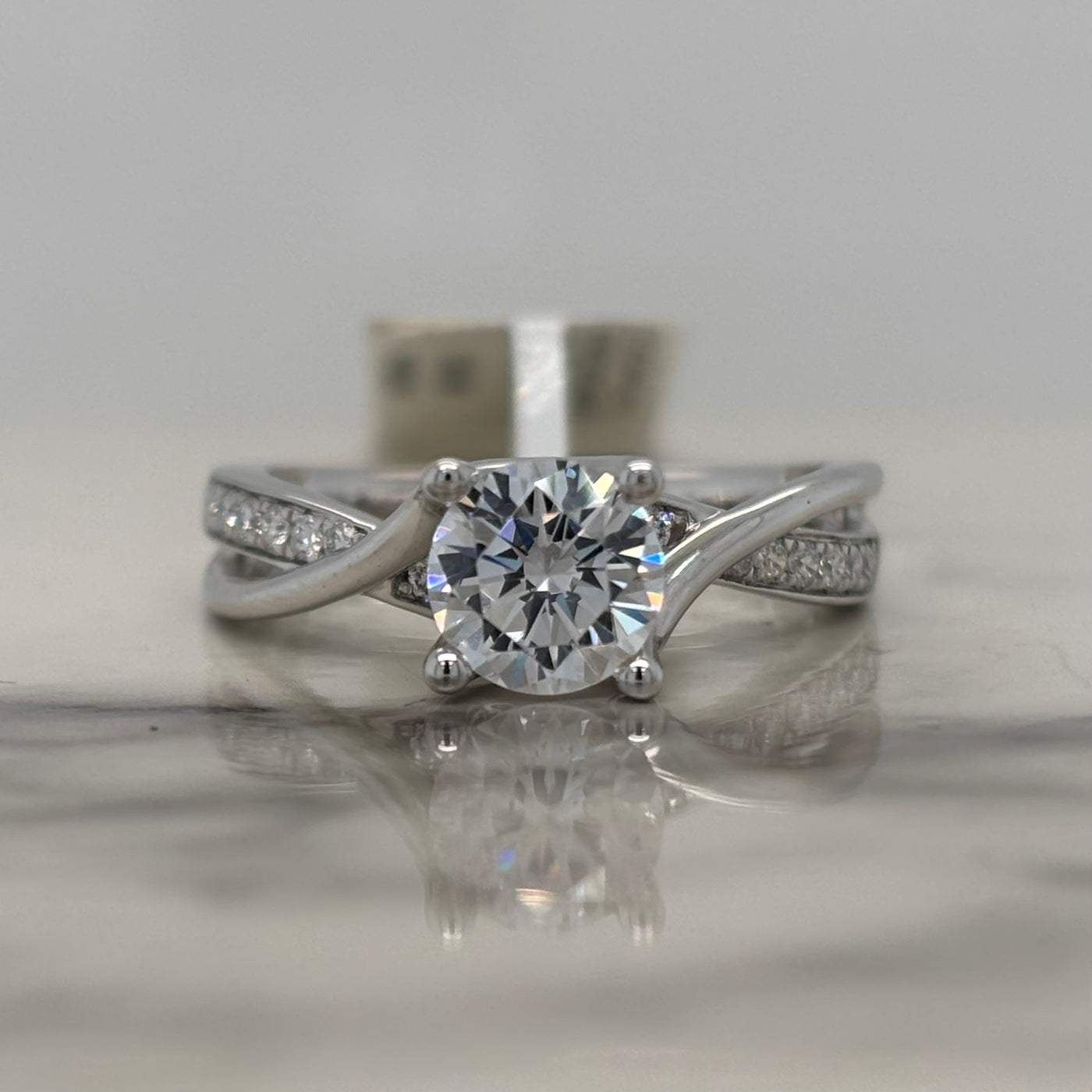 white gold semi mount engagement ring with round diamond accent stones and twist design