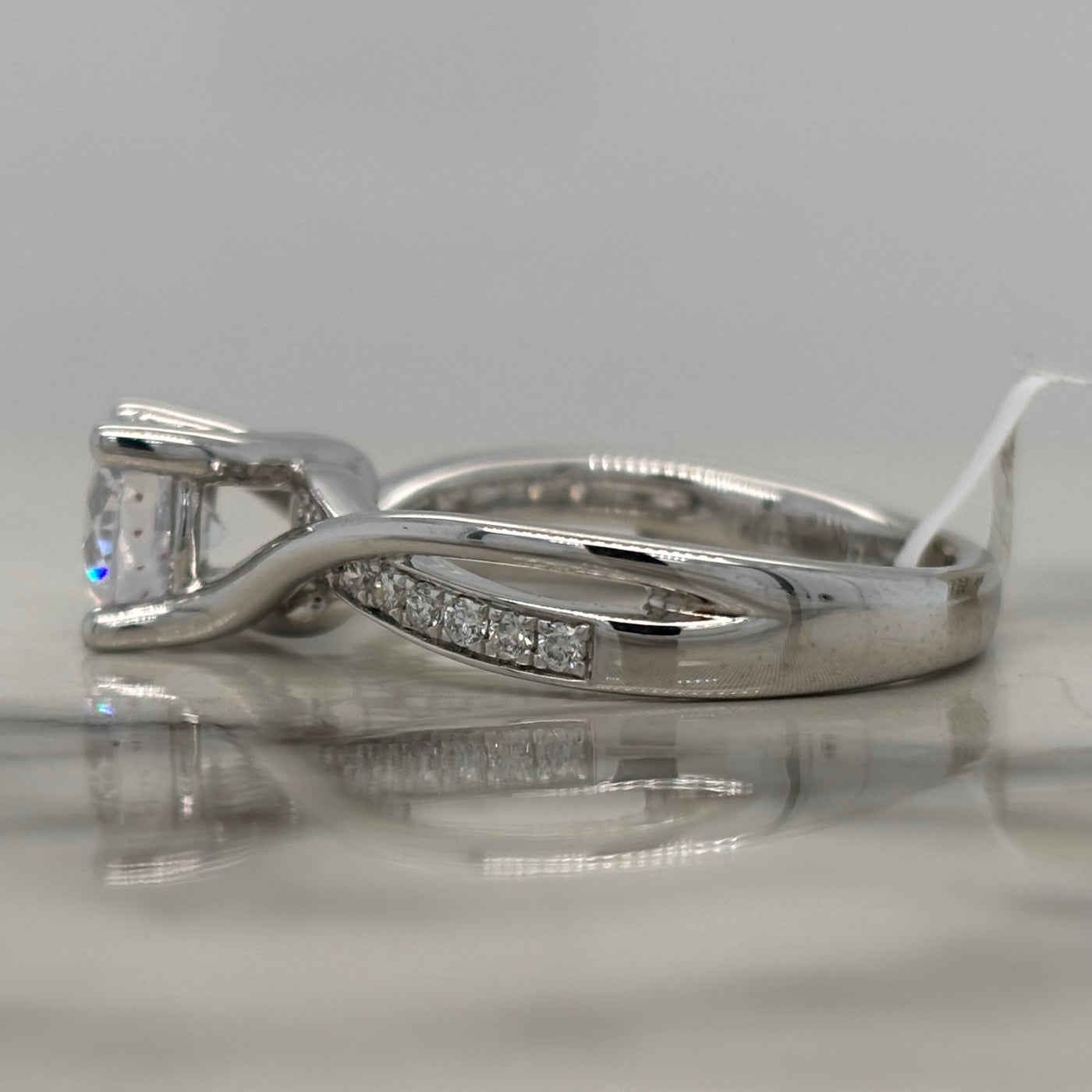 white gold semi mount engagement ring with round diamond accent stones and twist design