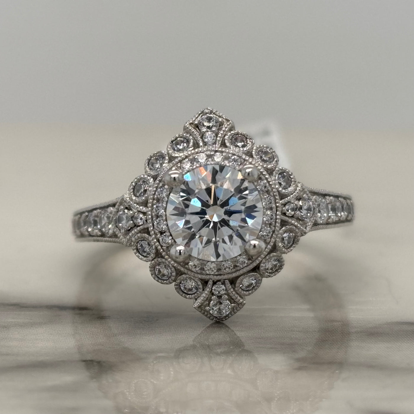 white gold vintage style round engagement ring with accent diamonds and milgrain detail