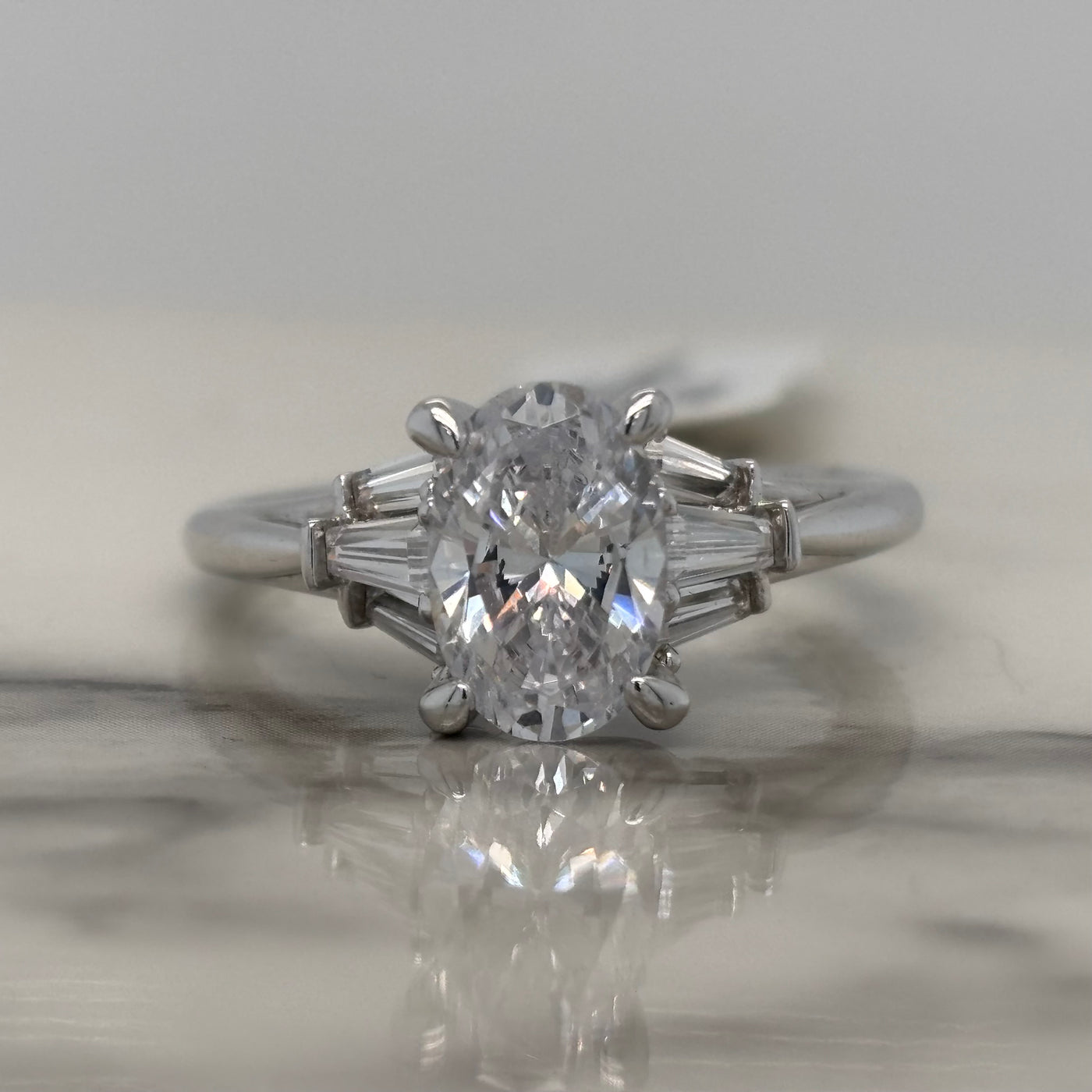 white gold oval engagement ring with tapered baguette side stones