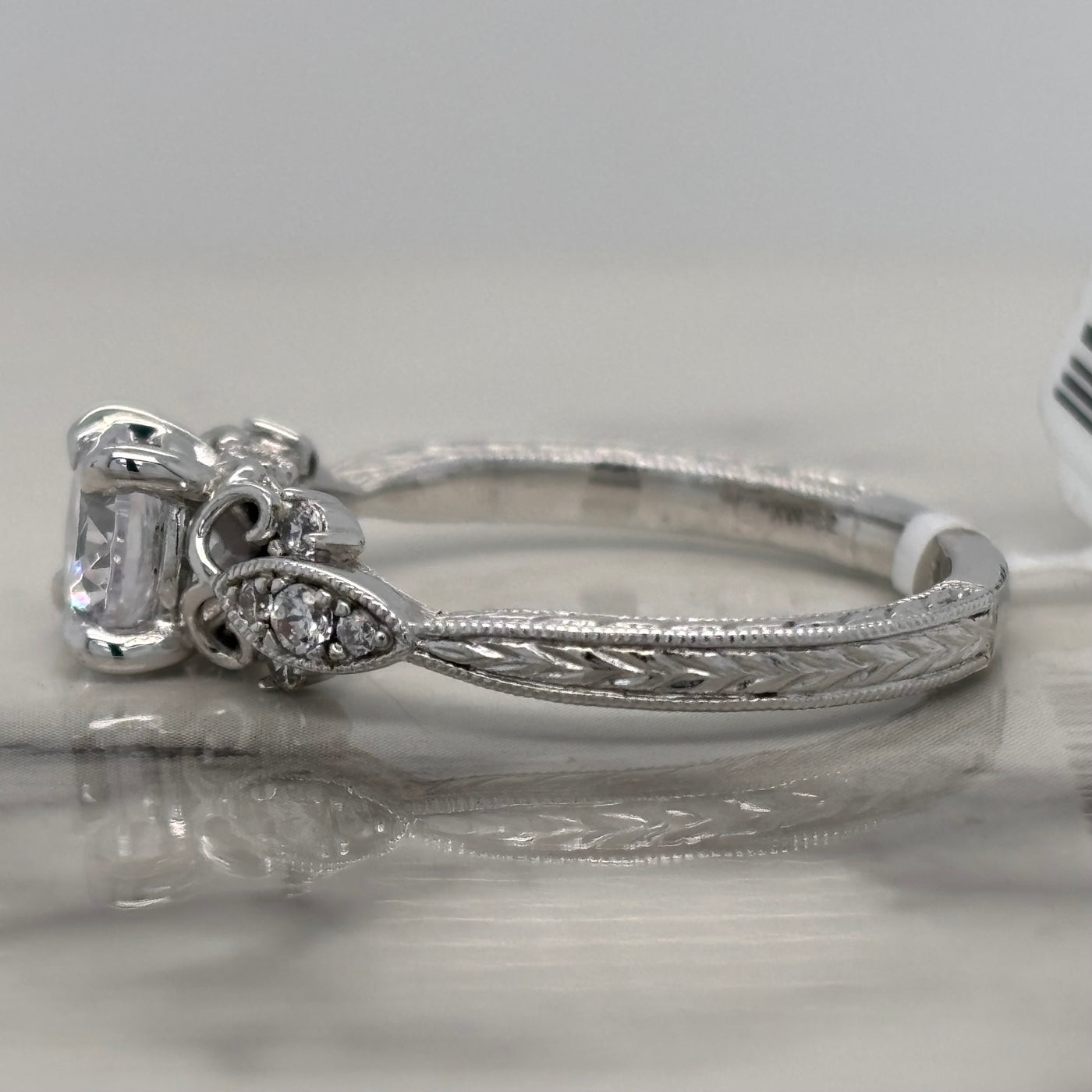 white gold round engagement ring with floral milgrain detail and accent diamonds