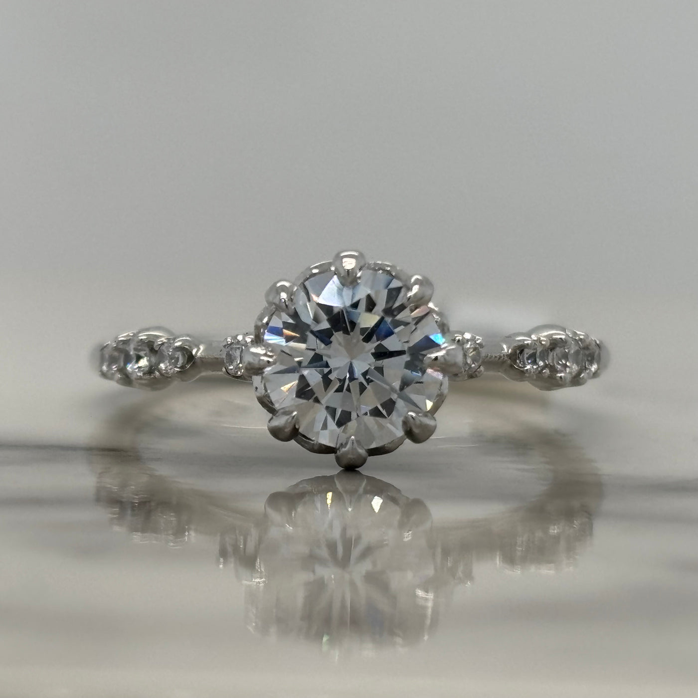 white gold round 8 prong engagement ring with accent diamonds and floral detail