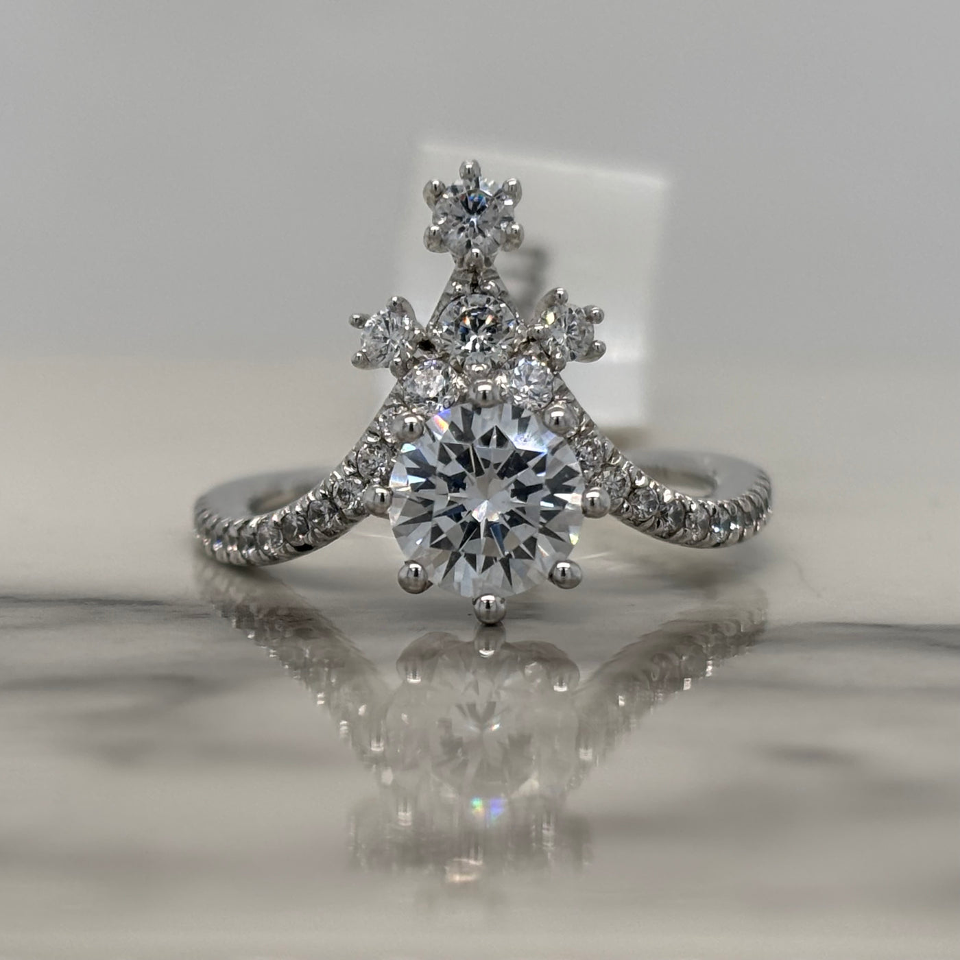 white gold round chevron engagement ring with round accent diamonds