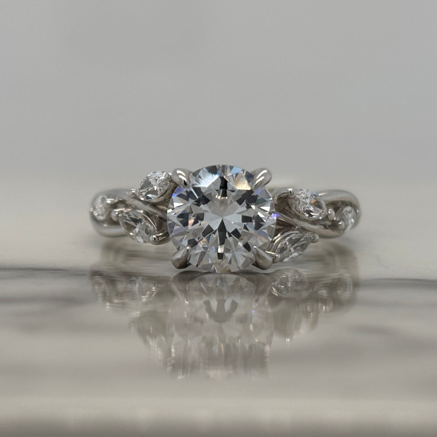 White Gold Round Engagement Ring With Floral Marquise Diamond Accents and Twist Design