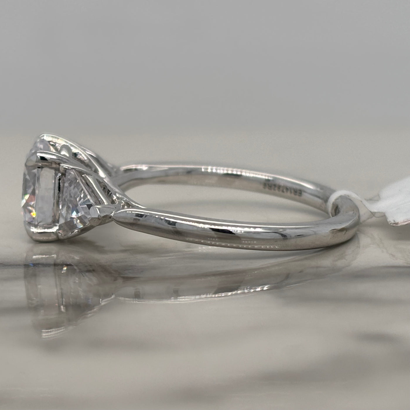 White Gold Round Three Stone Engagement Ring With Trillion Side Stones
