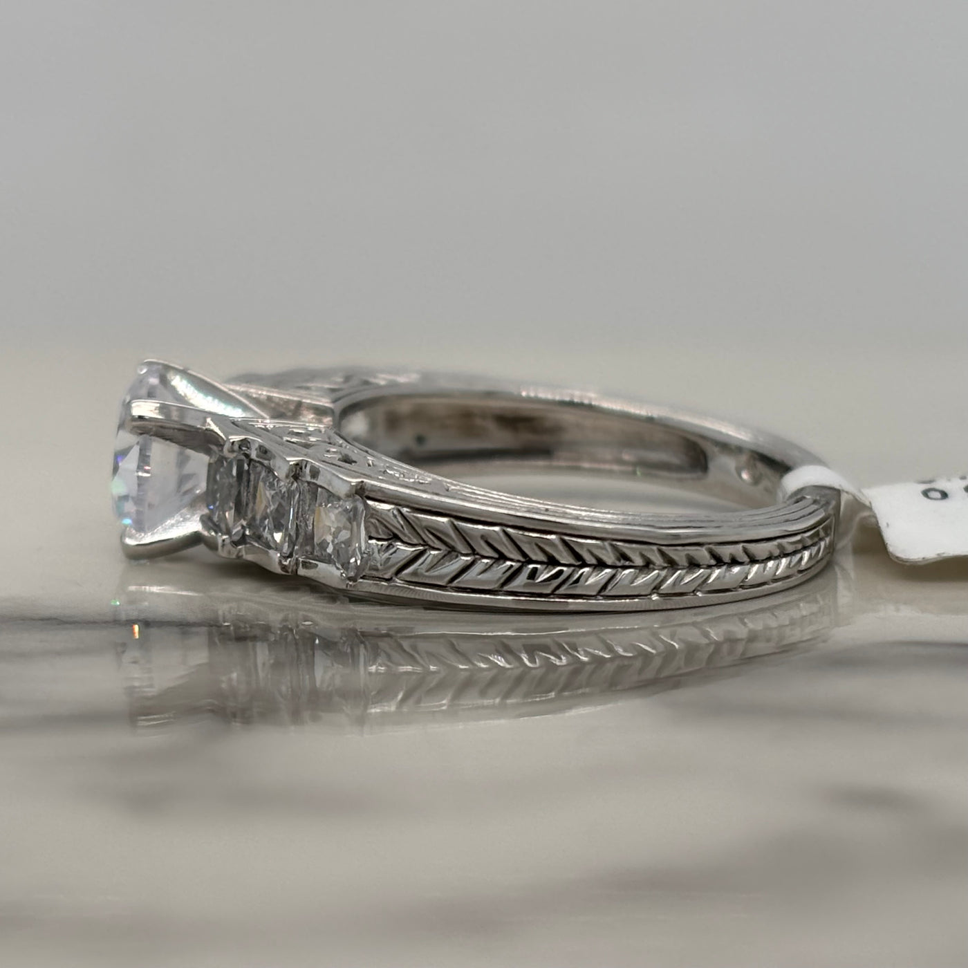 White Gold Round Engagement Ring With Channel Set Princess Cut Side Stones